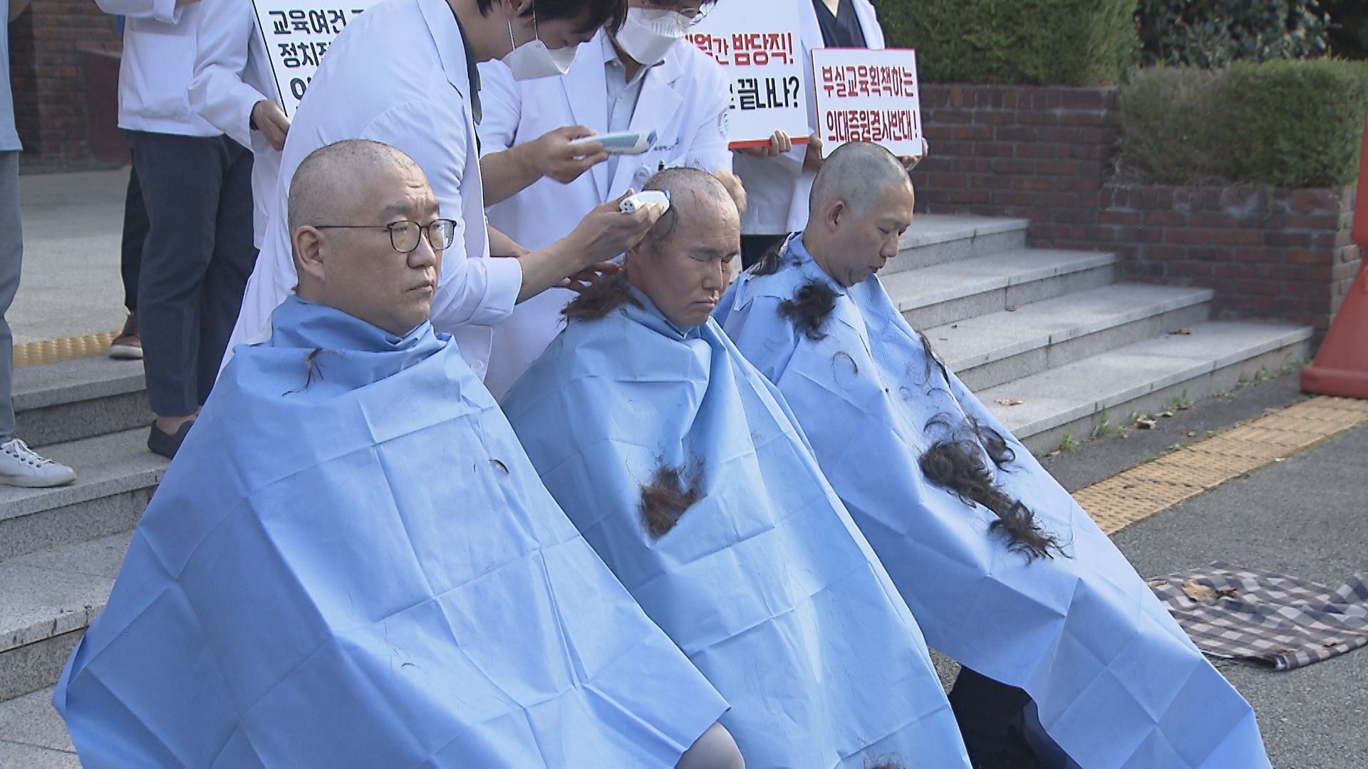 강원대와 고려대, 충북대학교 의과대학 교수 비상대책위원장 3명이 9일 충북대학교 의대 앞에서 정부의 의대 증원 정책에 반발하며 삭발하는 모습.